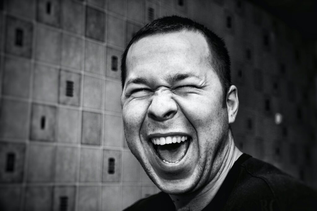 Emotional man laughing hard in black and white showing emotion-driven marketing results. 